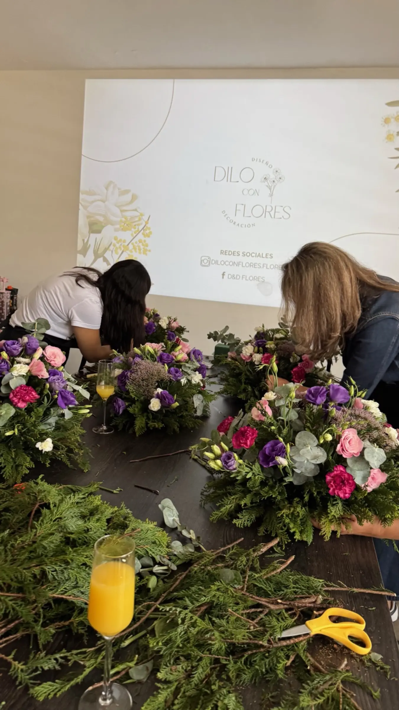 Participantes creando arreglos en un taller de Dilo Con Flores